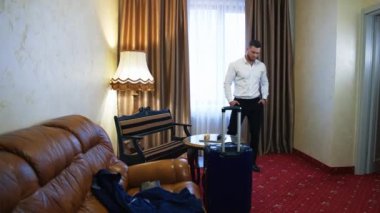 Otel odasındaki yakışıklı adam. Genç işadamı otele geldi ve yorucu bir yolculuktan sonra koltuğa oturdu..