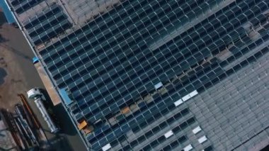 Binanın çatısındaki mavi güneş panelleri. Yenilikçi fotovoltaik güneş hücrelerinin yapımı. Alternatif enerji kaynağı. Kamera aşağı iniyor. Hava görünümü.