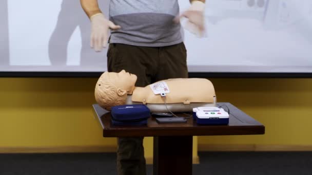 マネキンで医療スキルを教えるトレーナー ダミーに最初の援助を与えるための実用的な方法を示すインストラクター 医療コンセプト — ストック動画