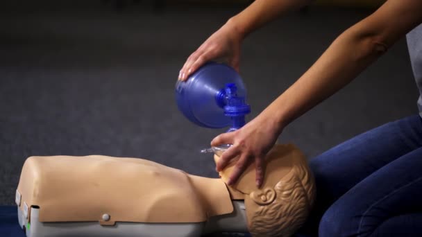 ダミーについての教え方 トレーニングセンターのマネキンの蘇生の医学デモンストレーション 医療機器による呼吸運動を示すインストラクター — ストック動画
