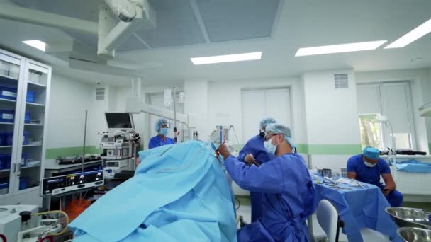 現代の外科室の医師のチーム 病院の保護マスクと制服の外科医のグループ 患者さんに手術をする医療スタッフ — ストック動画