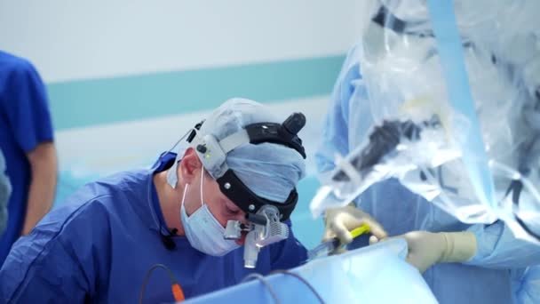 Cerrah Asistanlar Tıbbi Üniformalı Profesyonel Bir Doktor Başında Ameliyat Işıkları — Stok video