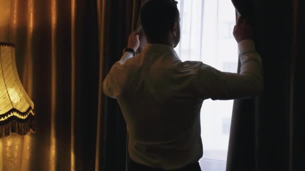 Otel Odasında Perdeleri Açan Genç Adam Beyaz Gömlekli Bir Adam — Stok video