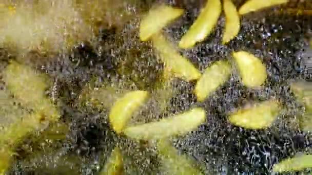 沸騰油のクリスピージャガイモ 深いフライヤーでフライドポテトを調理する際にホットオイルの泡 黄金のフライドポテトを調理するプロセス マクロショット — ストック動画