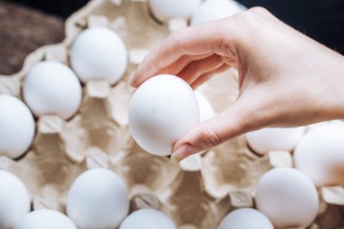 Bu büyüleyici sahnede, hassas bir el bir kutunun içine yerleştirilmiş değerli bir yumurtaya uzanır, merak ve hassasiyet hissi uyandırır..