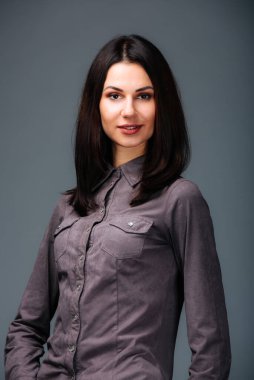 Zarifliğin büyüleyici özüne tanık olun. Karizmatik bir kadın, nefes kesici gri gömleğiyle zarafet ve çekicilik saçan bir resim için zahmetsizce poz verir..