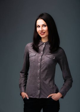 Büyüleyici bir ilham perisi, elleri kalçalarında rahatça dinlenirken, güç ve esneklik saçarak zarifçe ayakta durur..