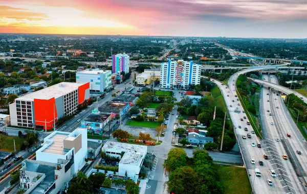 Aerial View of Miami City at Sunset. An incredible aerial perspective showcasing Miami City bathed in the warm hues of a stunning sunset.