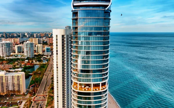 Aerial View of Tall Building Next to the Ocean in Miami, USA. This image depicts an aerial view of a tall building situated alongside the ocean in Miami, USA.