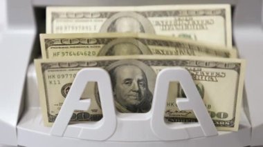 Dolar banknotlarının sayımı. Otomatik finansal operasyonlar. Para sayma makinesi 100 dolar sayıyor. Bankacılık ve ticari faaliyet. Yakın plan..
