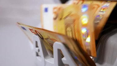 Modern bankacılık faaliyetleri. Sayılırken Avro banknotları. Bir veznedarın eli sayaç makinesinden para alıyor. Yakın plan..