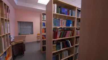 Kütüphanedeki ahşap kitaplıklar. Kütüphane odasındaki kitaplıklarda farklı kitaplar var. Eğitim ve bilgi kavramı.