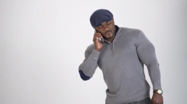 Telefonu olan Afrikalı bir işadamı. Stüdyoda durmuş, ciddi ciddi telefonla konuşan esmer tenli bir sporcunun portresi. Boşluğu kopyala.