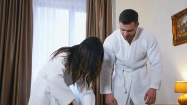 Otelde eşyaları olan genç bir çift. Beyaz bornozlu bir adam ve kadın otele vardıktan sonra bavulu boşaltıyorlar. Balayı tatili.