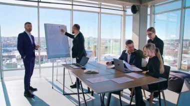İş adamlarının takım çalışması. Şehrin arka planında geniş pencereli modern ofis manzarası. İş merkezinde birlikte çalışan bir grup işadamı..