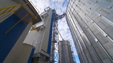 Modern tarım endüstrisi. Gün ışığında büyük gümüş silolar. Gökyüzü arka planında tahıl asansörleri. Depo tankları açık havada. Yakın plan..