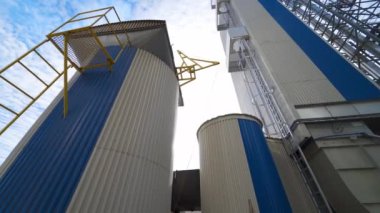 Modern bir fabrikanın dışı. Tarımsal ürünleri işlemek ve kurutmak için büyük bir ambar. Tahıl asansörü açık havada. Yakın plan..