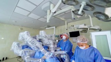 Tıbbi ekipmanlı modern cerrahi odası. Cerrahi robotla işletim süreci. Doktor ve hemşire robot cerrahisini kontrol ediyor. Yenilikçi tıp konsepti.