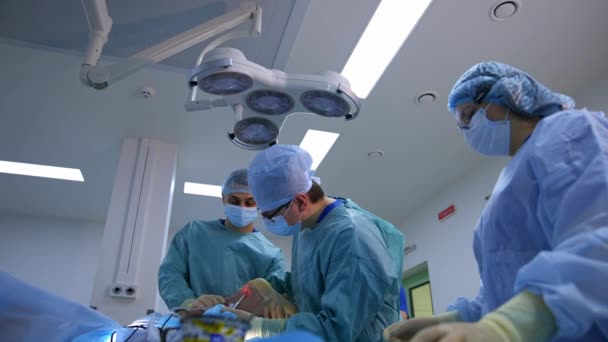 現代のクリニックでの手術 医療専門家が病院で手術を行っている 医師とアシスタントが手術器具で手術を行う — ストック動画