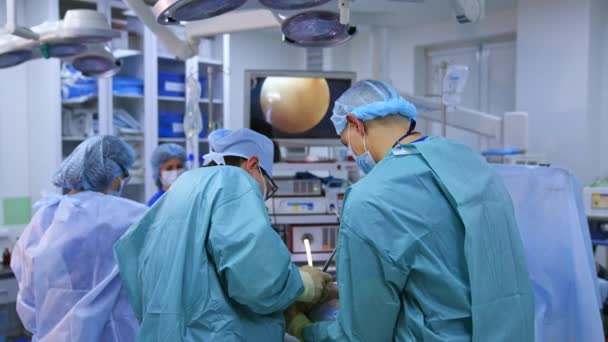 手术室里的一组外科医生 在现代医疗柜工作 专业医生和护士为外科病人做手术 — 图库视频影像