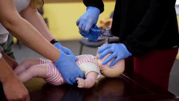 学生们在洋娃娃上练习Cpr 教授用假人拯救生命的适当医疗程序的教师 — 图库视频影像