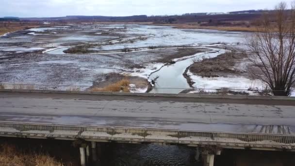 荒凉的自然景观 受污染的河流在泥泞的背景下漂浮在桥下 生态问题 从上面看 — 图库视频影像