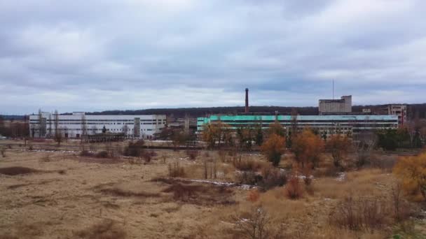 自然の中の古い破壊された工場 灰色の空の下に放棄された植物の大きな破壊された建物の正面の景色 — ストック動画