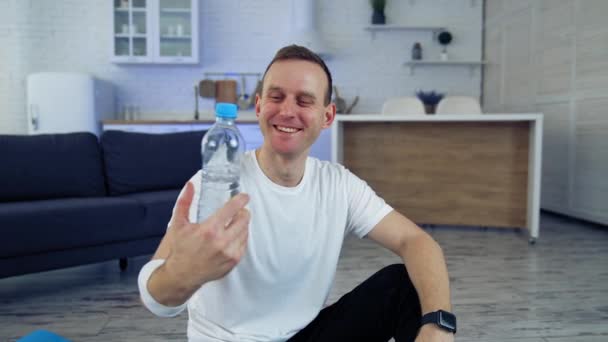 Улыбающийся Молодой Человек Бутылкой Воды Дома Молодой Человек Предлагает Пресную — стоковое видео