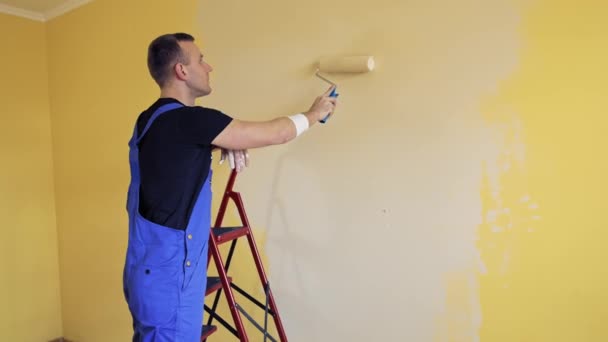 Человек Синем Комбинезоне Красил Комнату Рабочий Рисует Стены Комнате Помощью — стоковое видео