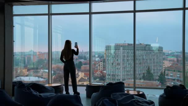 Młoda Kobieta Telefonem Przy Oknie Panoramiczny Widok Biuro Dużymi Oknami — Wideo stockowe