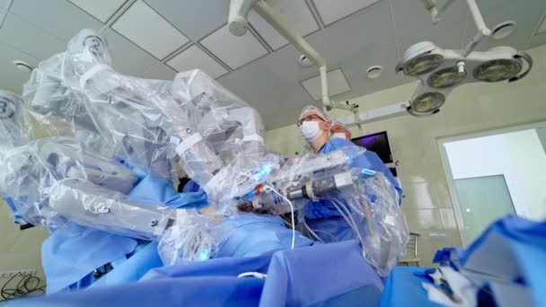 医療ロボットによる未来動作 診療所で最小侵襲ロボット手術 医学における新しい技術 外科医はロボット装置の仕事を制御する — ストック動画