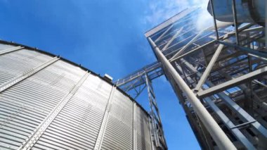 Modern bir fabrikada tahıl kurutmak. Büyük tahıl asansörü ve endüstriden gelen duman. Buğday işleme sırasında endüstriyel fabrikadan buhar çıkıyor..