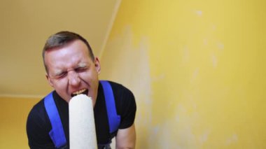 Duvarları boyayan komik bir zanaatkar. Oda yenileme çalışmaları sırasında boya silindirinde şarkı söyleyen neşeli genç bir erkek işçi..