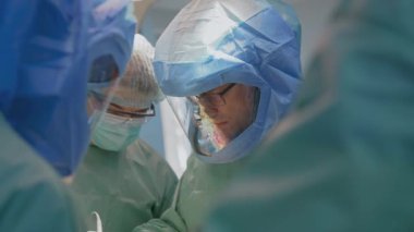 Salgın krizinde güvenlik kıyafeti giyen bir grup doktor. Bir grup cerrah klinikte koruyucu kıyafet giyerek ameliyat yapıyor. Covid 19.