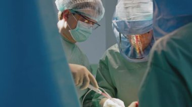 Doktorların cerrahi prosedürü. Güvenli tıbbi giysiler içindeki cerrahlar klinikte bir operasyon gerçekleştiriyor. Virüs krizi sırasında ameliyat. Sağlık hizmeti kavramı.