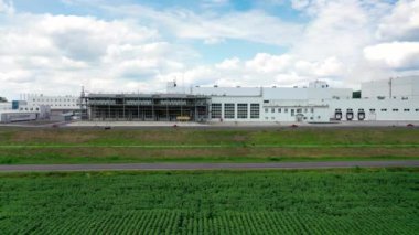 Gökyüzünün altında büyük, yenilikçi bir bitki. Sahada beyaz binalar olan modern endüstri. Ön manzara. Hareket kamerası sağa..