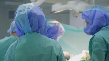 Güvenlik elbiseli doktorlar. Korunma üniforması uzmanlarından oluşan bir ekip Coronavirus salgını sırasında ameliyathanede birlikte çalışırlar. Arka plan.