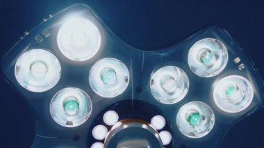 Kliniğin tavanından gelen parlak tıbbi yıldırım. Ameliyathanede tıbbi lambalar var. Yakın plan. Aşağıdan görüntüle.