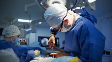Profesyonel doktor cerrahi aletle ameliyat yapar. Cerrah ve hemşire klinikte ameliyat yapıyor. Sağlık hizmeti kavramı.