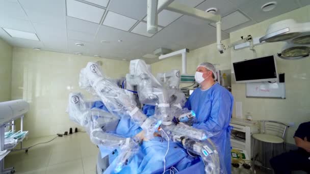 医療用外科ロボットが手術を行っています 自動アームを使用した操作を行うロボットマシン 侵襲手術を最小限に抑える現代医療機器 医師はロボット機械の仕事を制御する — ストック動画