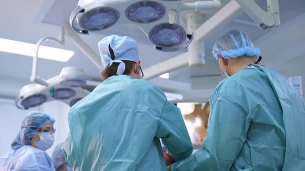 Operacja Nowoczesnej Klinice Widok Tylny Lekarzy Mundurze Medycznym Wykonujących Operację — Wideo stockowe