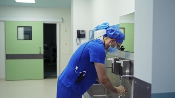 クリニックでの消毒手順 外科医は手術前に手を徹底的に洗っています 手術前に手洗いをする男性医師 クォータータン コヴィド — ストック動画
