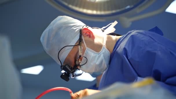 戴眼镜的外科医生做手术 医疗面罩和在诊所做手术的专用设备的专业医生 保健概念 — 图库视频影像