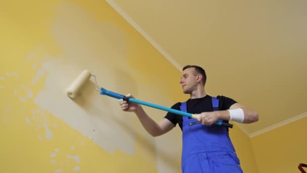 Malíř Práci Maluje Stěnu Válečkem Pracovník Modrých Montérkách Dělá Rekonstrukci — Stock video
