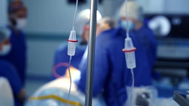 オペレーティングルームの不規則なドリップ 外科医チームの手術の背景にあるドリッパー — ストック動画