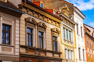 Brasov, Romanya, Transilvanya 'daki City Street' teki Binalar Sırası. Canlı bir şehir caddesinde, büyüleyici Transilvanya mimarisini aydınlatan bir sıra binanın resimli görüntüsü..