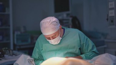 Estetik ameliyat. Hastane üniformalı ve maskeli bir cerrah hastanede bir hastaya ameliyat yapıyor. Ceset taşımak için tıbbi prosedür.