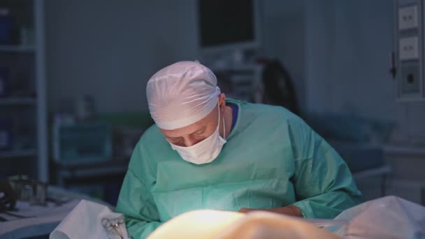 プラスチック手術 医療用ユニフォームとマスクの外科医は 病院の患者に手術を行っています ボディ持ち上がることのための医療処置 — ストック動画