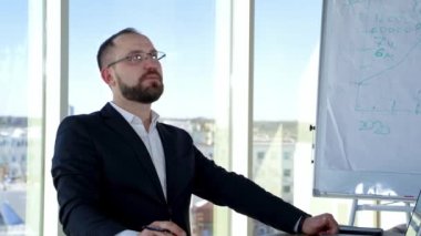 Ofis merkezinde gözlüklü, sakallı bir iş adamı. Zarif kostümlü başarılı bir ofis çalışanı. İş yerinde, pencerenin yanında oturuyor ve konuşuyor..