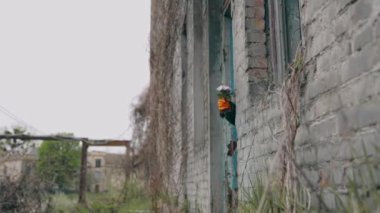 Terk edilmiş yerde taze çiçeklerle el. Kimyasal saldırıdan sonra terk edilmiş bir yer. Koruyucu eldivendeki insan eli çiçekleri tutar. Ekolojik felaket.